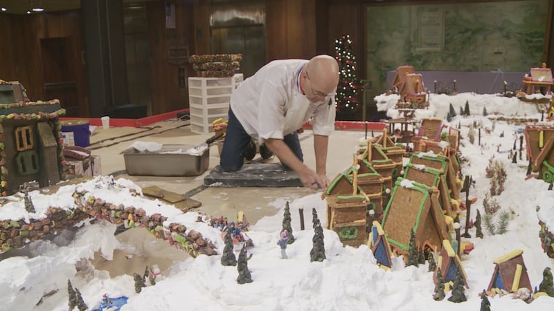 Joe Hickel works on adding to the massive gingerbread village he creates every year at the...