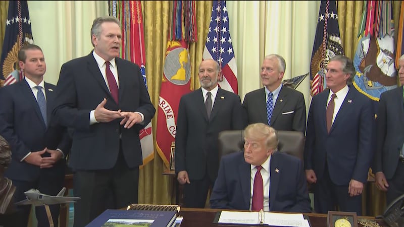 Alaska's Republican Gov. Mike Dunleavy (left) praises President Donald Trump (seated) for a...