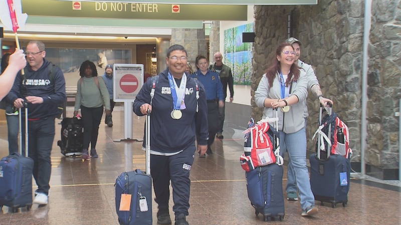 Gold medalists Nathaniel Hunt (left) and Sulynette Vega Ledesma (right) arrive at Ted Stevens...