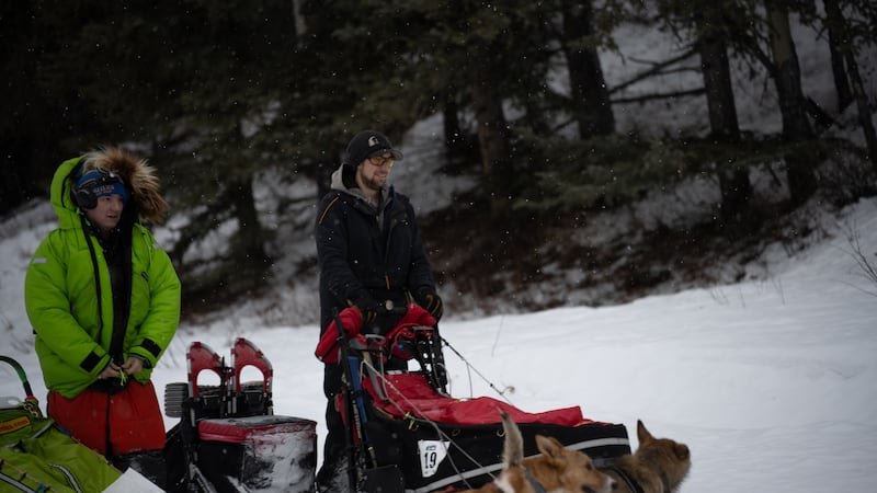 Ryan Redington, the 2023 Iditarod champion, looks as another musher makes his way down the trail.