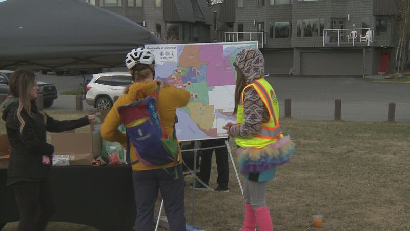 Two look at a map of the participating dump sites in southcentral Alaska.