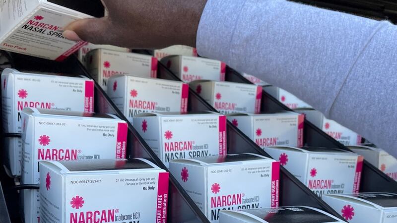 Boxes of two-doses of Narcan are lined up in the dispenser slots of a vending machine as...