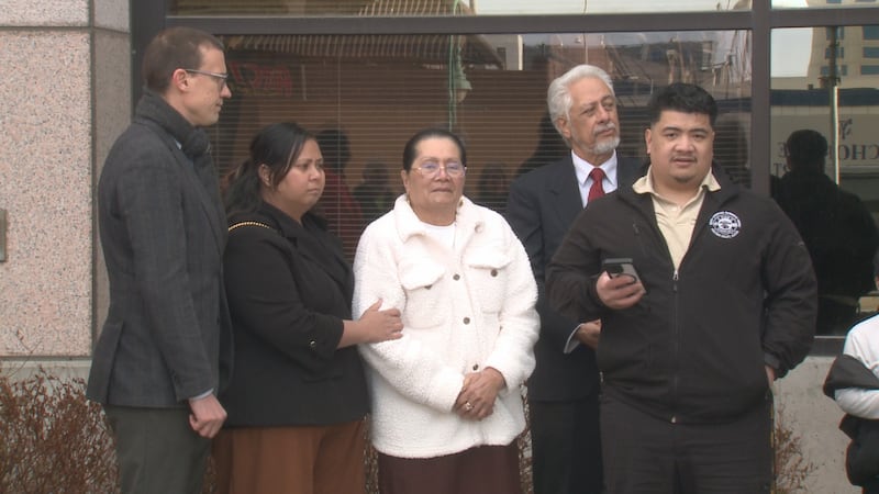 Michael Pese (far right) stands with his mother Miliama Suli (center) and wife Tupe Smith...