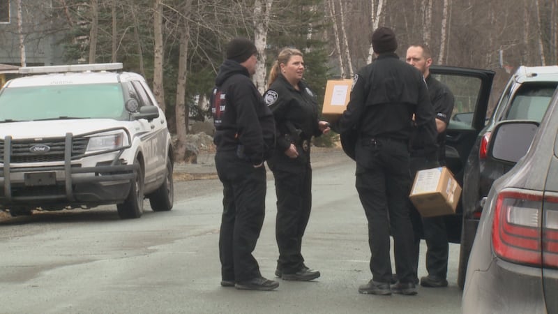 Police remove boxes on Thursday from a duplex directly behind the home of a missing Eagle...