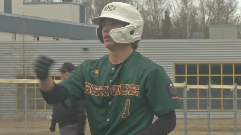 Service's Rilen Niclai tosses gear towards the dugout after getting on base vs Chugiak