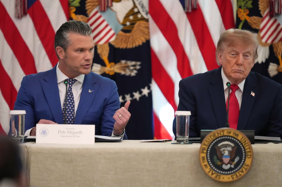 President Donald Trump listens as Defense Secretary Pete Hegseth speaks at a roundtable event...