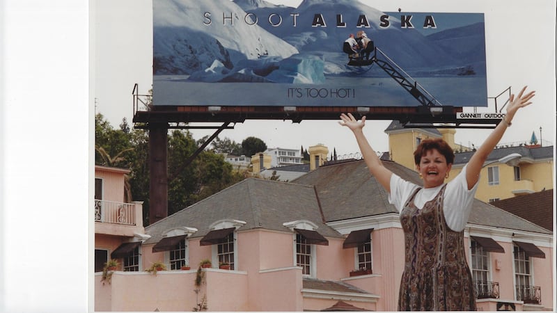 Mary P. in front of a billboard on Sunset Blvd. in California.