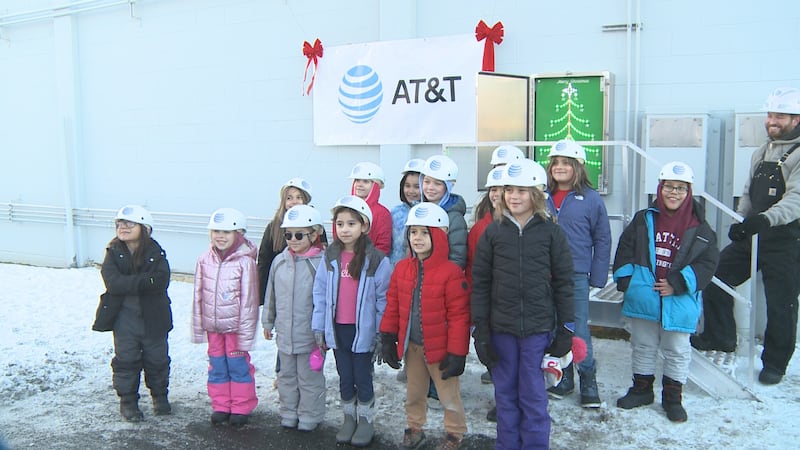14 students from Government Hill Elementary pose for a picture in front of the switchbox where...