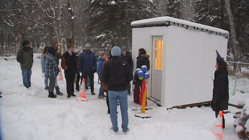 Stream Academy teachers and students gather outside a tiny home the students designed and...