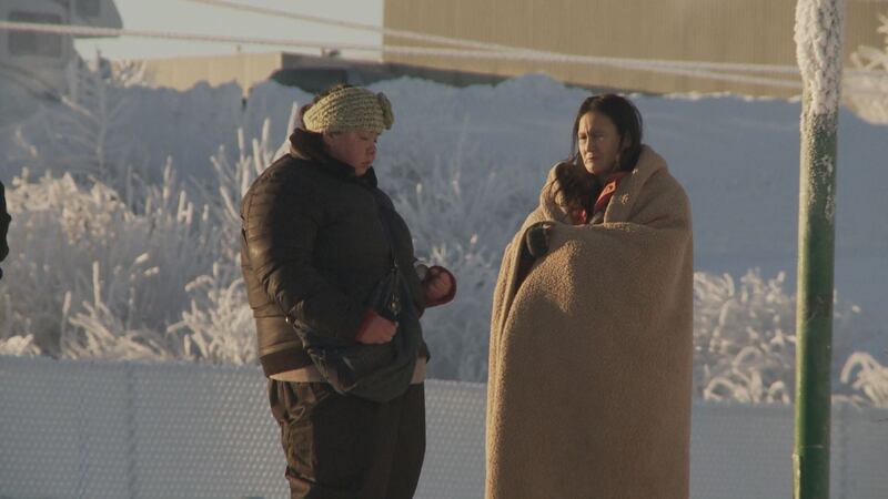 Two women stand outside Bean's Cafe, bundled against the cold. (KTUU)