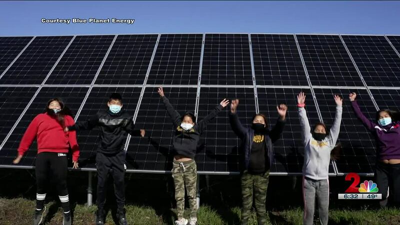 Children from the village of Shungnak pose in front of solar panels at their community's...