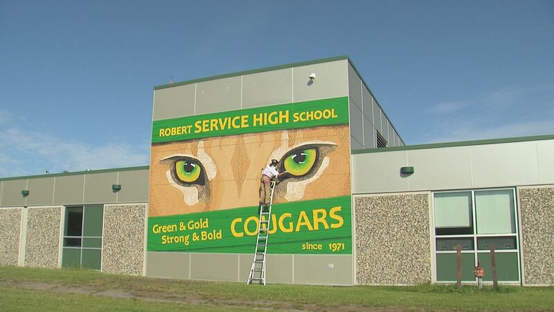 Artist Jen Jollif paints a mascot mural on the side of Service High School